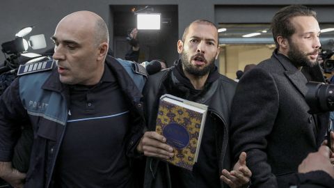 Andrew Tate, center, was pictured carrying a copy of the Quran in Bucharest, Romania on January 26, 2023. He claimed to have converted to Islam in October.