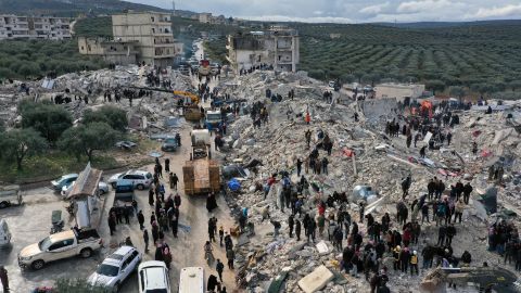 Εργαζόμενοι στον τομέα της πολιτικής άμυνας και κάτοικοι ερευνούν μέσα από τα ερείπια κτιρίων που κατέρρευσαν στην πόλη Χαρέμ κοντά στα τουρκικά σύνορα, στην επαρχία Ιντλίμπ, στη Συρία, τη Δευτέρα.
