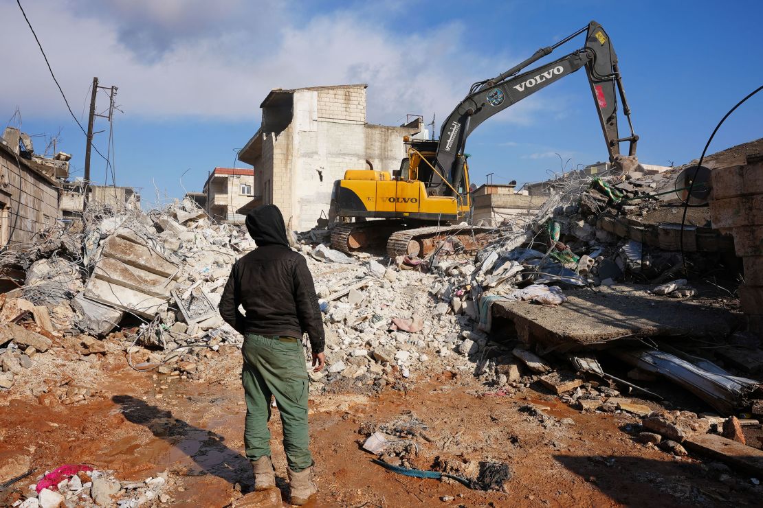 An excavator digs through the rubble of a house in which the entire family except a newborn baby was killed, on February 7, 2023, in the town of Jandaris.
