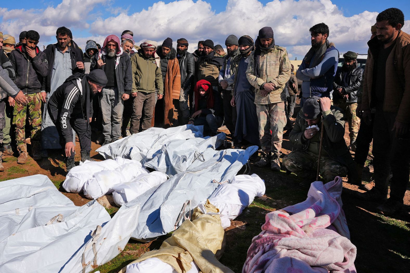 People in the Syrian village of Hajji Iskandar mourn over the bodies of a family and close neighbors who were killed in the quake.