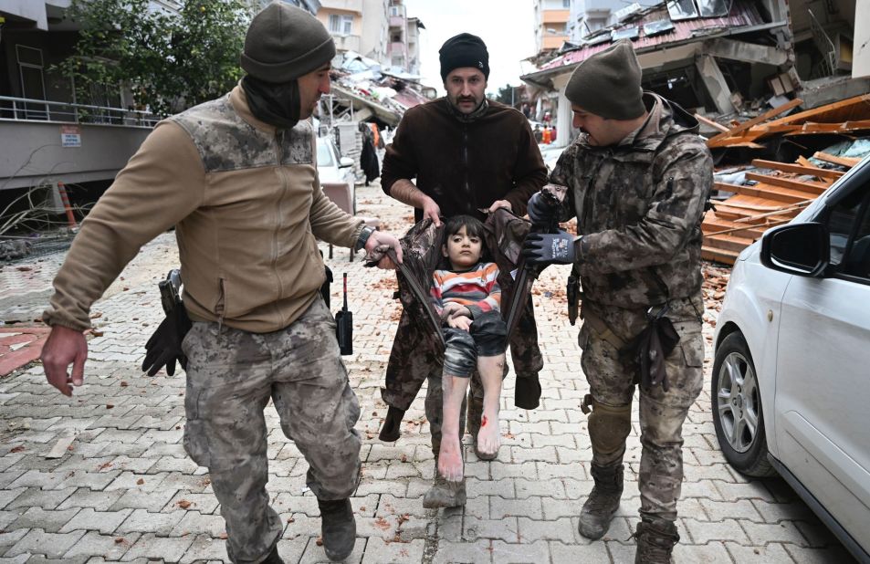 Police carry a child who was rescued from rubble in Hatay on February 7.