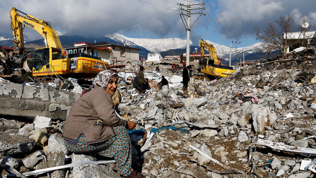 A woman sits amid the rubble and damage in Gaziantep on Tuesday.