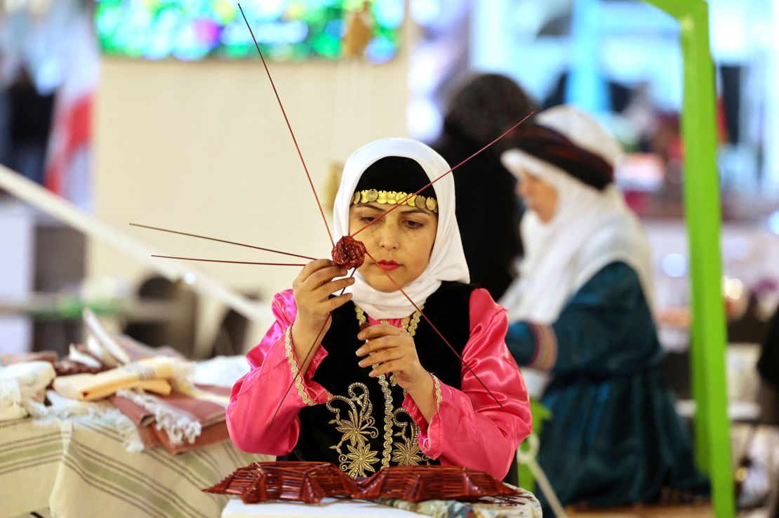 A craftswoman takes part in the 16th International Exhibition of Tourism and Related Industries in Tehran, Iran on Tuesday.  