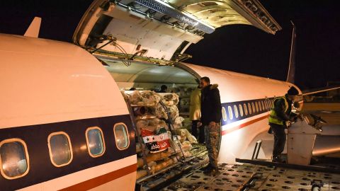 Workers unload aid sent by Iran at the airport in Syria's northern city of Aleppo early on February 8, 2023.