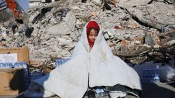 A girl sits near the site of a collapsed building following an earthquake in Kahramanmaras, Turkey February 8, 2023. REUTERS/Dilara Senkaya