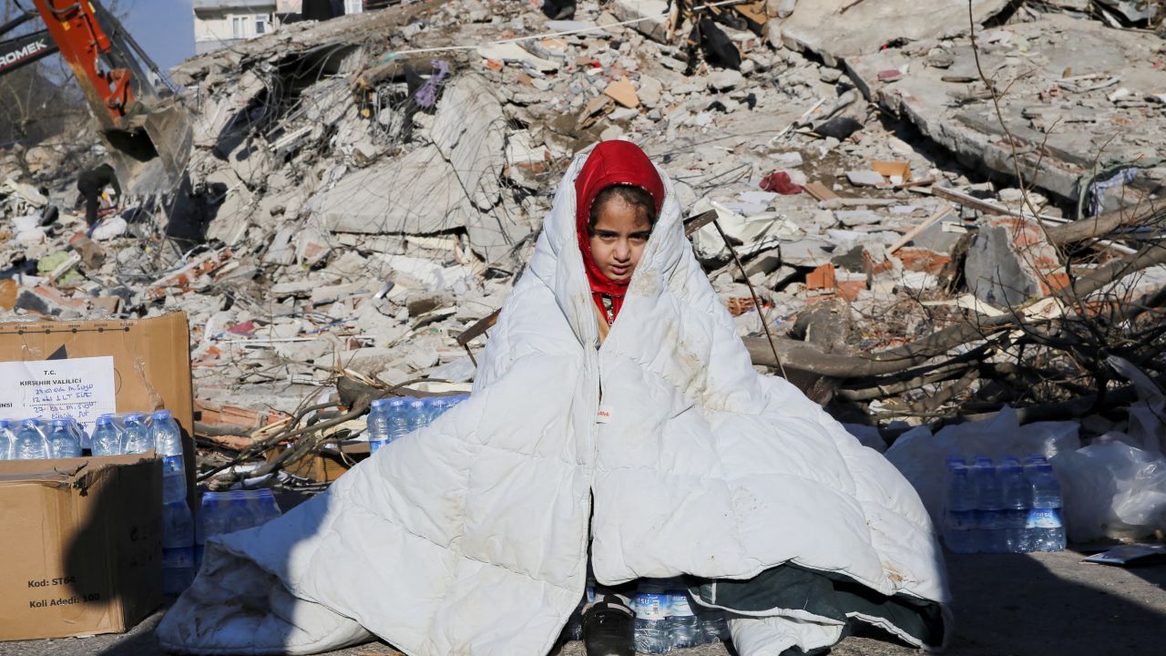 A girl sits near the site of a collapsed building following an earthquake in Kahramanmaras, Turkey, on Wednesday.