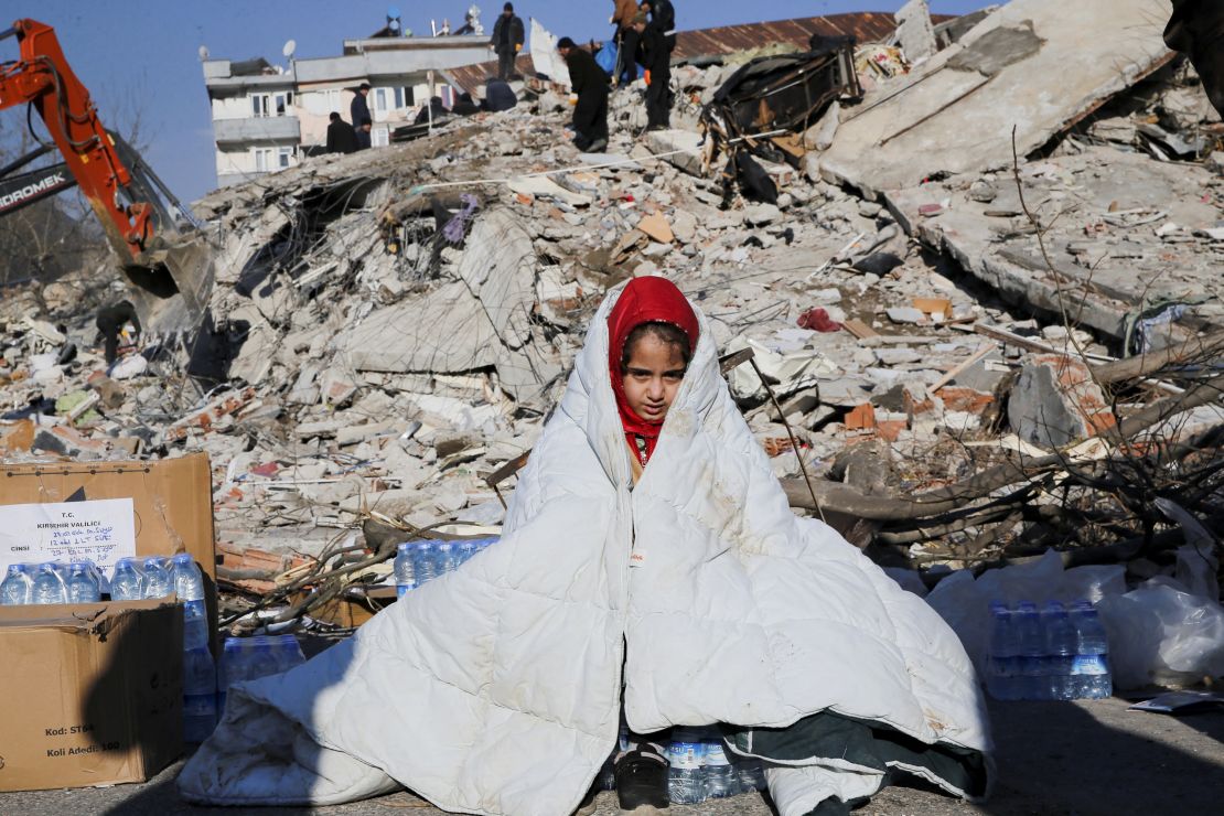 A girl sits near the site of a collapsed building following an earthquake in Kahramanmaras, Turkey, on Wednesday.