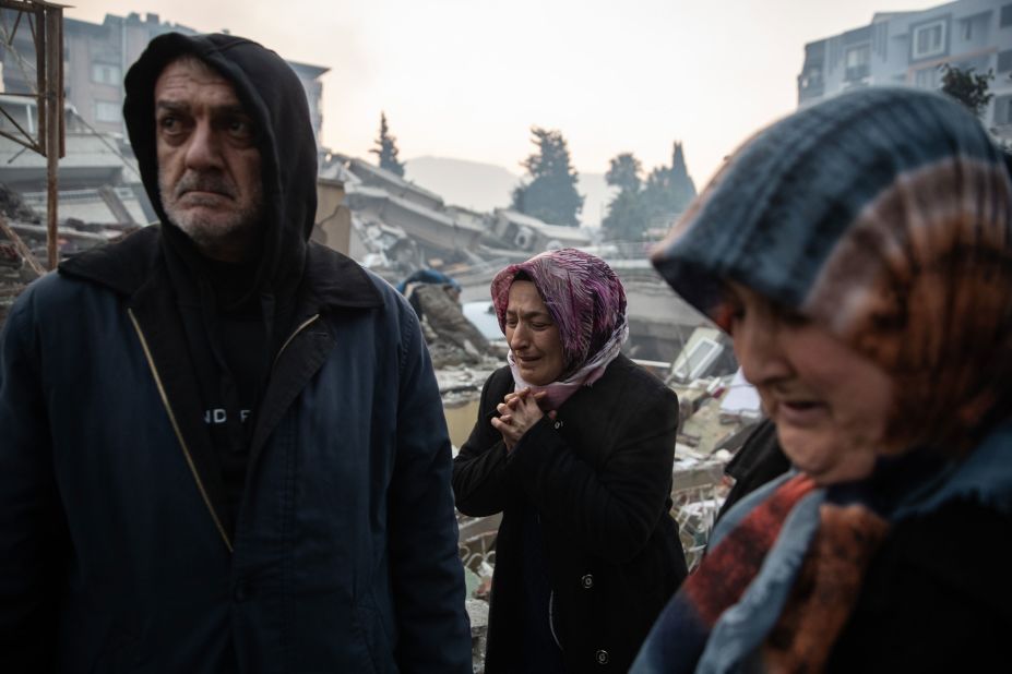 People wait for news of their loved ones, who were believed to be trapped under a collapsed building in Hatay on February 7.