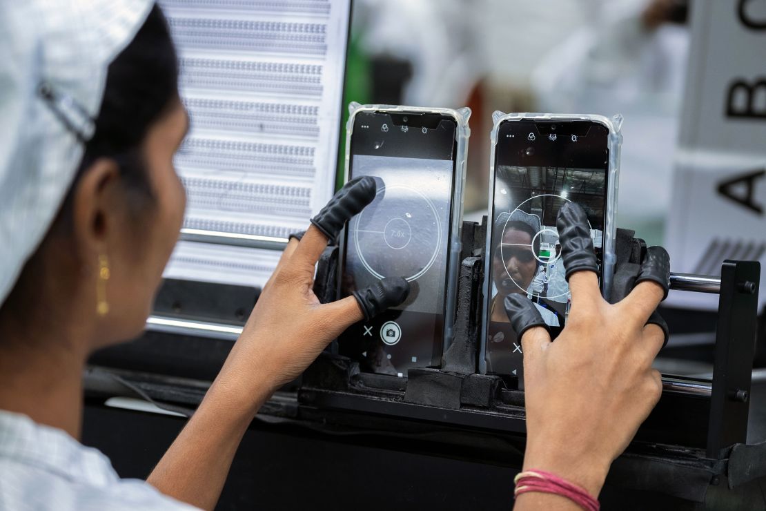 An employee tests the camera quality of mobile phones on an assembly line at a unit of Foxconn Technology Co., in Sri City, Andhra pradesh, India. 