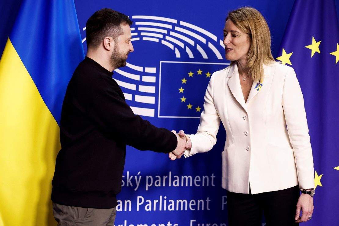 Ukraine's president Volodymyr Zelensky (L) shakes hands with European Parliament President Roberta Metsola as he arrives for a summit at EU parliament in Brussels, on February 9, 2023. - Ukraine's President is set to attend an EU summit in Brussels on February 9, 2023, as the guest of honour where he will press allies to deliver fighter jets "as soon as possible" in the war against Russia. (Photo by Kenzo TRIBOUILLARD / AFP) (Photo by KENZO TRIBOUILLARD/AFP via Getty Images)