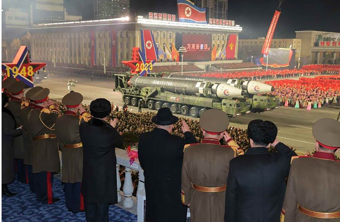 North Korean intercontinental ballistic missiles move past leader Kim Jong Un in a reviewing stand during Wednesday night's military parade in Pyongyang.