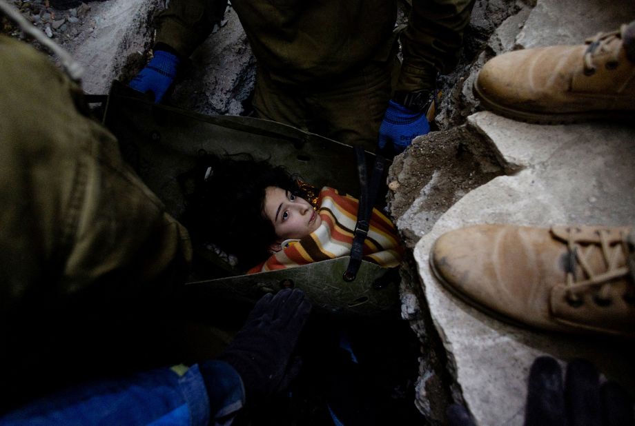 Rescuers move a 14-year-old girl from under some rubble in Kahramanmaras on February 9.