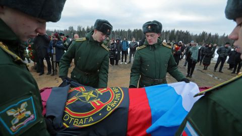 Military academy cadets cover the coffin with flags during the funeral of a Wagner Group mercenary, killed in the conflict in Ukraine, at a cemetery in St. Petersburg, Russia, on December 24, 2022.