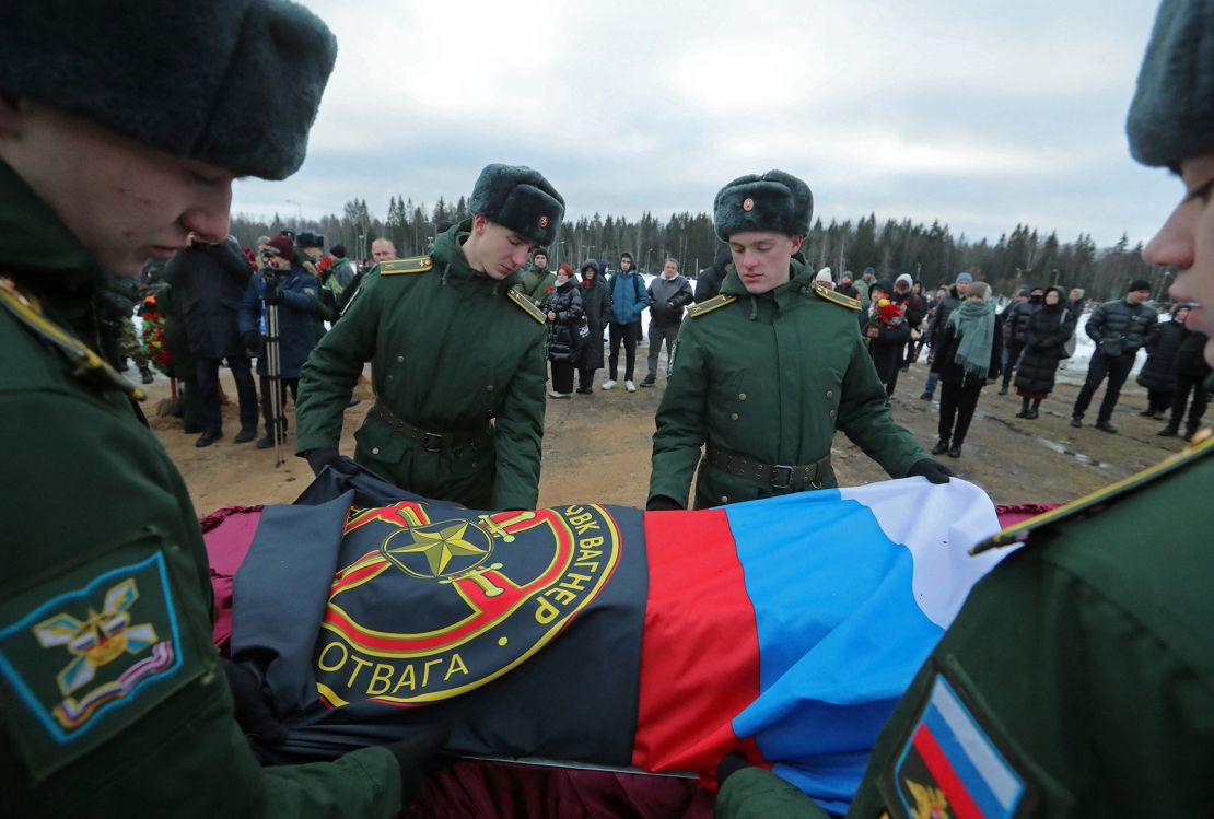 Military academy cadets cover the coffin with flags during the funeral of a Wagner Group mercenary, killed in the conflict in Ukraine, at a cemetery in St. Petersburg, Russia, on December 24, 2022.