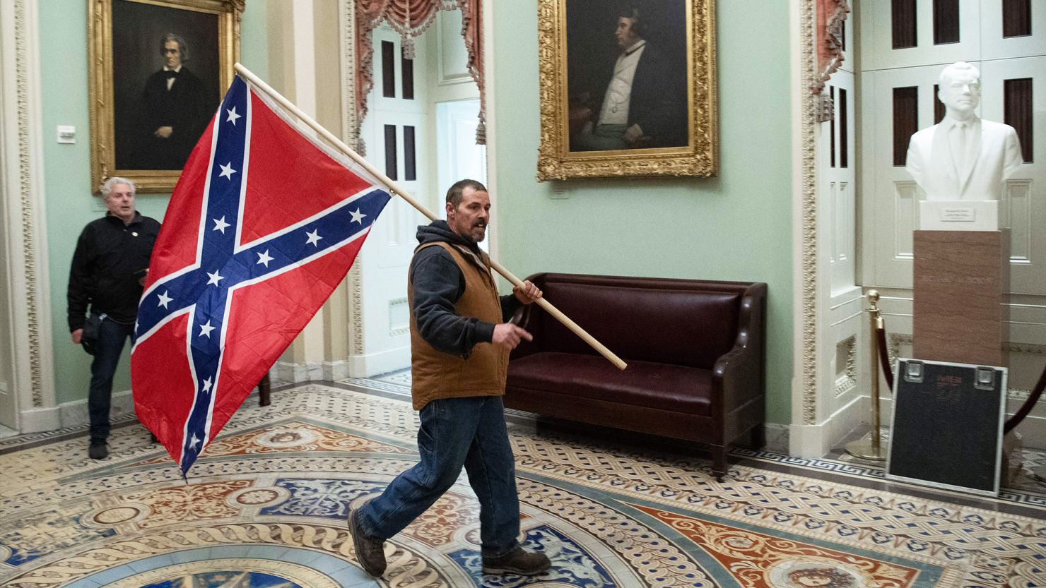  Kevin Seefried carries a Confederate battle flag on the second floor of the US Capitol on January 6, 2021. 