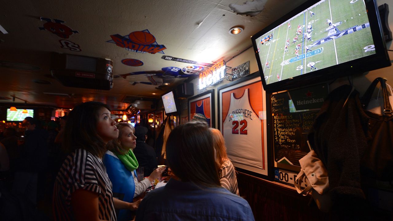 Fans watch Super Bowl XLVIII between the Denver Broncos and the Seattle Seahawks on television at a sports bar in New Jersey, on February 2, 2014.