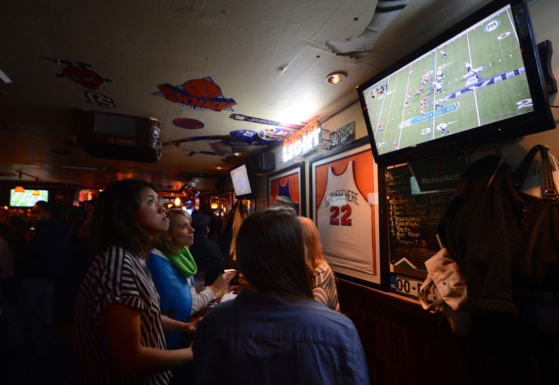 Fans watch Super Bowl XLVIII between the Denver Broncos and the Seattle Seahawks on television at a sports bar in New Jersey, on February 2, 2014.