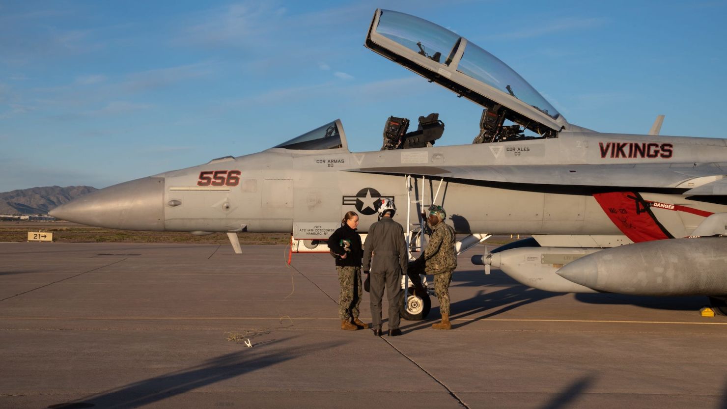 Caitlin Hillygus (left) and Nathaneal Airiyie (right) instruct Tareq Salameh before his incentive flight in front of an EA-18G Growler on February 8, 2023, at Luke Air Force Base in Glendale.