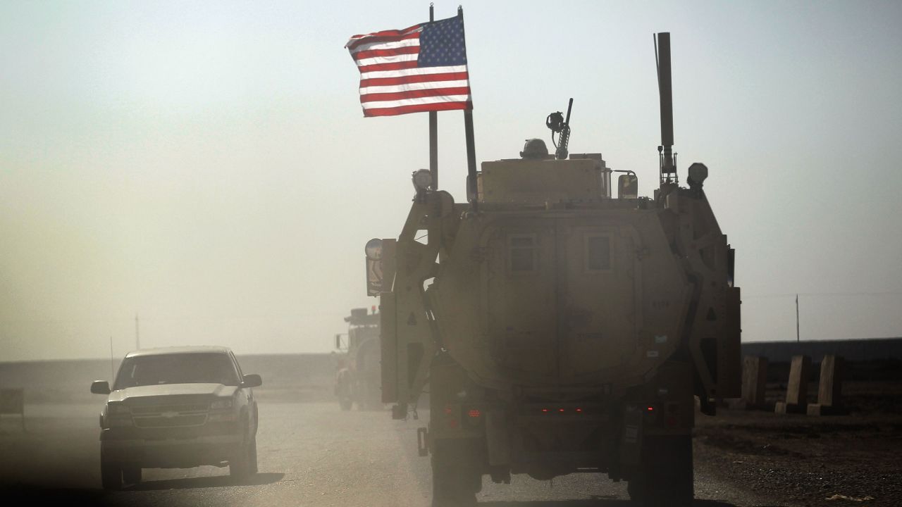 NASIRIYAH, IRAQ - DECEMBER 02: A U.S. Army armored vehicle flies an American flag as it provides security escort for a convoy of vehicles pulling equipment that is heading to Kuwait from Camp Adder as the Army continues to send it's soldiers and equipment home and the base is prepared to be handed back to the Iraqi government later this month on December 2, 2011 at Camp Adder, near Nasiriyah, Iraq.  The United States military continues its pullout of the country by the end of this year, after eight years of war and the overthrow of Saddam Hussein.  (Photo by Joe Raedle/Getty Images)