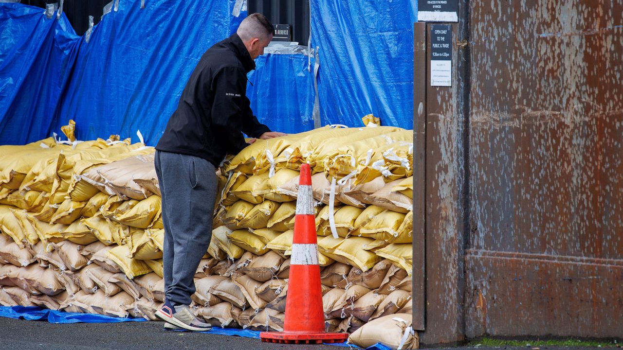 A man stacks up sandbags to protect a warehouse before the arrival of Cyclone Gabrielle in Auckland, New Zealand, on February 12, 2023.