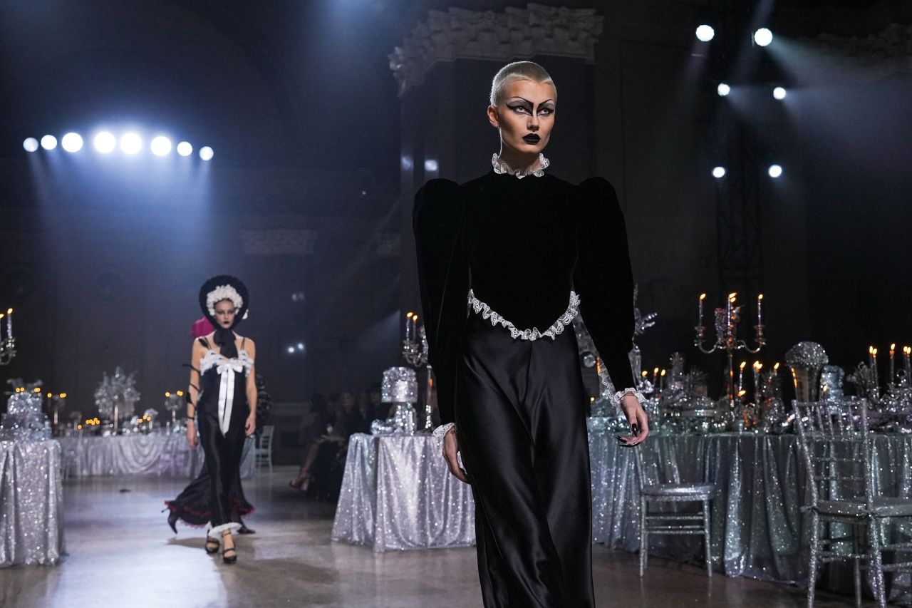 Rodarte set the scene with silver banquet tables overflowing with glitter-covered fruits and candelabras. Models wore garments inspired by gothic fairies, ranging from moody all-black dresses to winged metallic gowns.