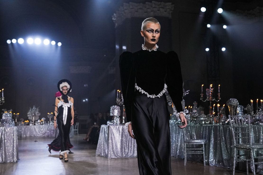 Rodarte set the scene with silver banquet tables overflowing with glitter-covered fruits and candelabras. Models wore garments inspired by gothic fairies, ranging from moody all-black dresses to winged metallic gowns.