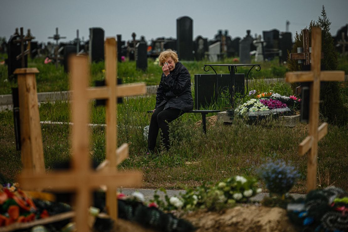 A woman visits the grave of a Ukrainian serviceman, in the military section of a Kharkiv cemetery, May 21, 2022. 