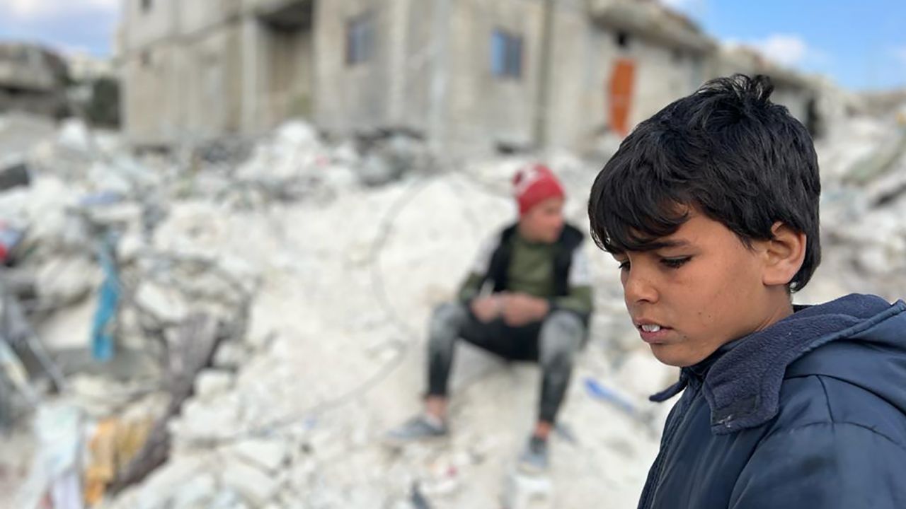 A child stands in the rubble that remains of his former home. Twenty-one members of his family died in the earthquake.