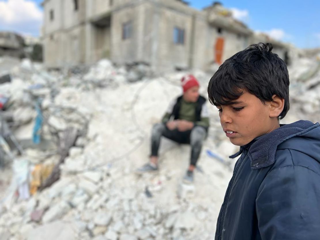 A child stands in the rubble that remains of his former home. Twenty-one members of his family died in the earthquake.