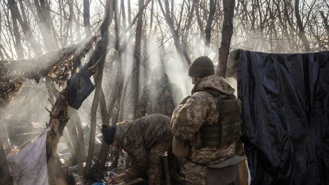 Miembros de una unidad de artillería ucraniana cortan leña mientras esperan cerca de Vuhledar en Donetsk.