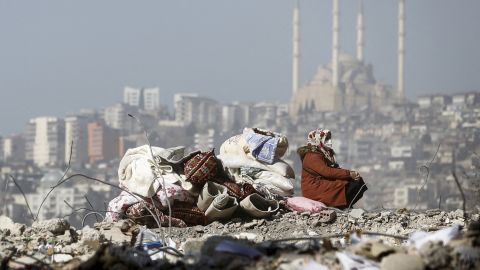 A woman sits on the rubble of her destroyed house on Tuesday in Kahramanmaras, Turkey.