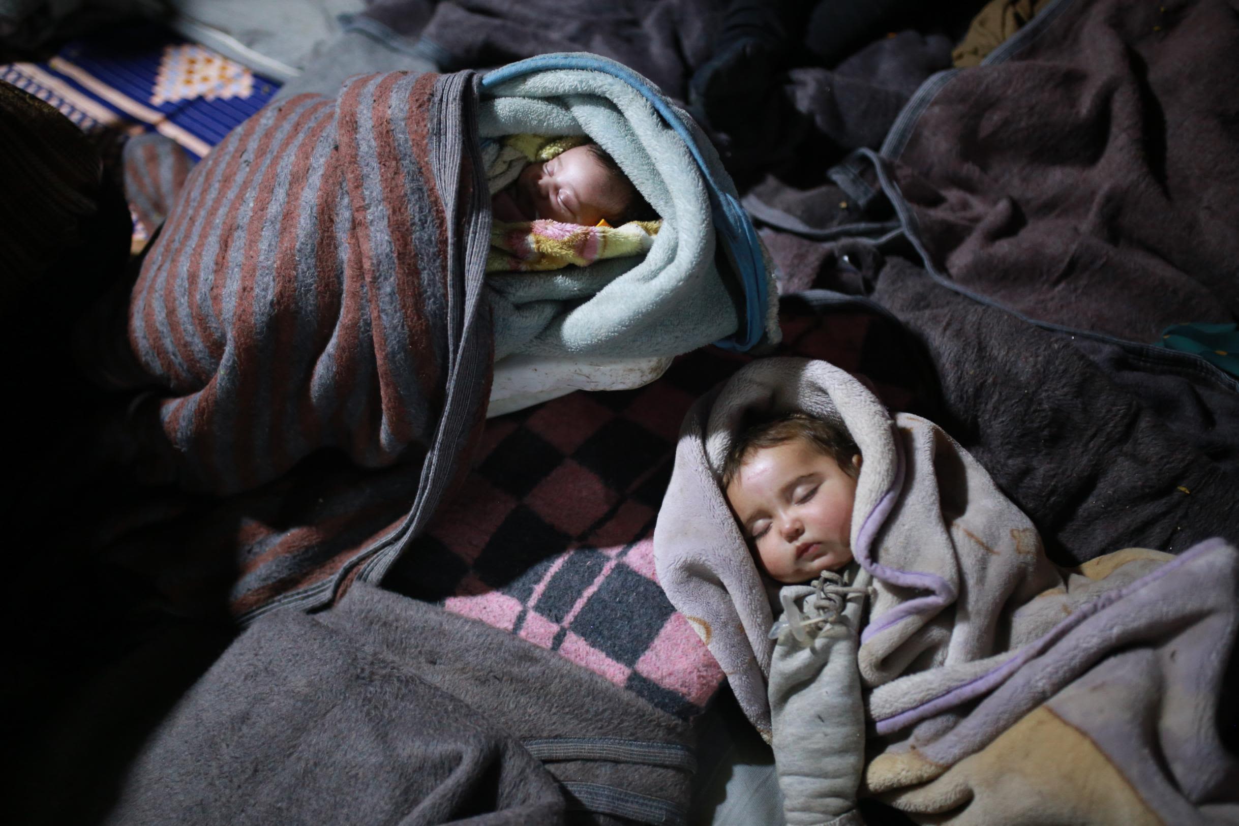 Children sleep in a tent in Idlib, Syria, where an amusement park was turned into a shelter for earthquake victims.