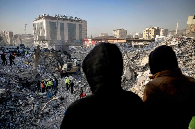 People wait near a collapsed building in Kahramanmaras, Turkey, hoping for news of their missing relatives on February 14.
