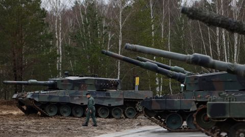 A Polish soldier walks next to Leopard 2 tanks at a military base in Poland.