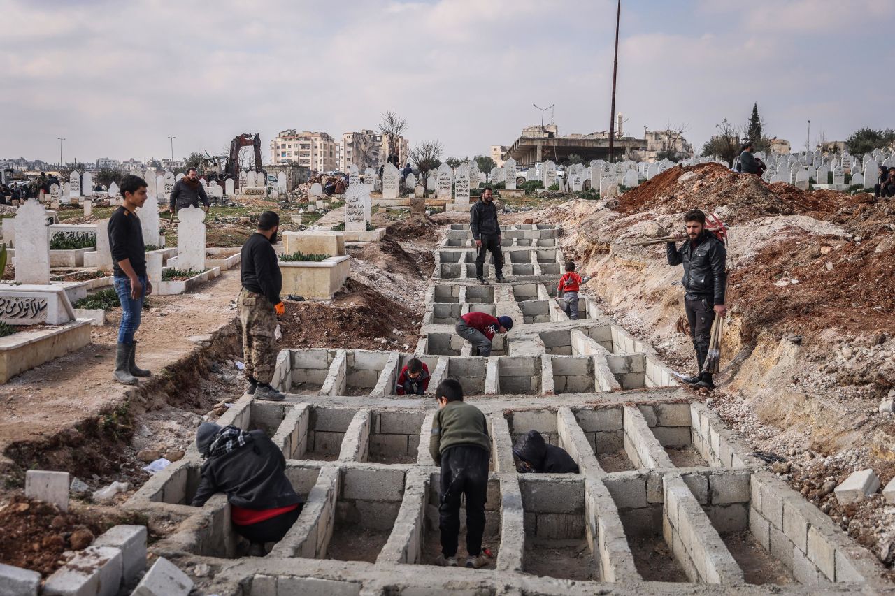 People dig graves for earthquake victims in Idlib on February 13.
