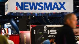 Signage for the Newsmax conservative television broadcasting network is displayed at a broadcast TV booth at the National Rifle Association (NRA) annual meeting at the George R. Brown Convention Center, in Houston, Texas on May 28, 2022.
