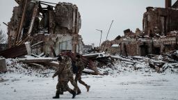 Ukrainian servicemen walk past a destroyed building in Kupiansk, Kharkiv region, on February 13, 2023, amid the Russian invasion of Ukraine. (Photo by YASUYOSHI CHIBA / AFP) (Photo by YASUYOSHI CHIBA/AFP via Getty Images)