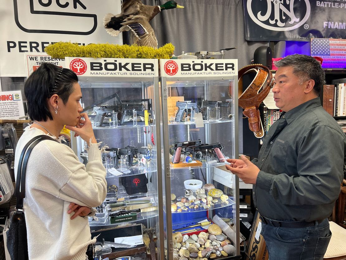 Kris He, left, and David Liu discuss a purchase at Liu's gun store.