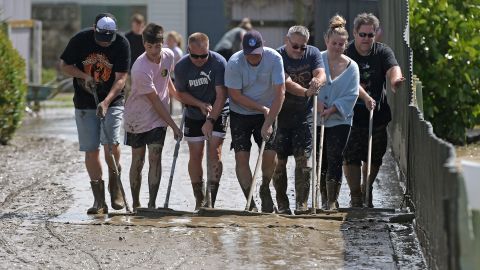 السكان ينظفون الطمي بعد مياه الفيضانات في 15 فبراير 2023 في نابير ، نيوزيلندا.