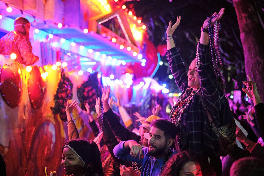 Crowds reach for beads and other throws as the Krewe of Bacchus parades by in New Orleans on February 27, 2022.