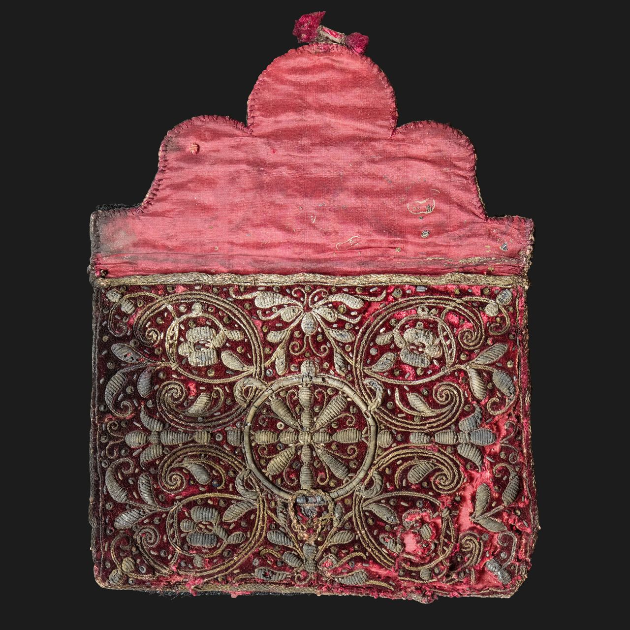This red silk case housed a woman's toiletry case, which still held a comb, brush, pincushion and mirror inside.