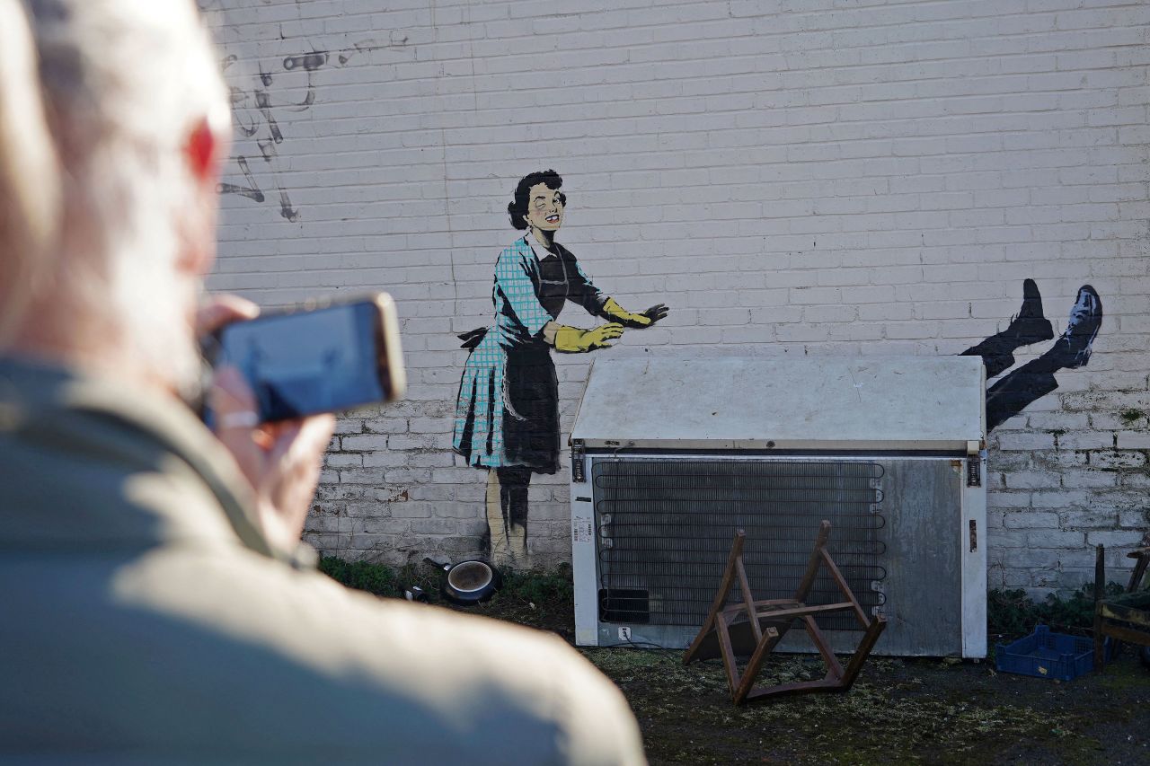 Someone takes a photo of a new Banksy mural in Margate, England, on Tuesday, February 14. <a href="https://www.cnn.com/style/article/banksy-valentines-day-mascara/index.html" target="_blank">The artwork</a>, "Valentine's day mascara," shows a 1950s housewife with a swollen eye apparently pushing a man into an abandoned chest freezer. The appliance was later removed on the grounds of safety and temporarily replaced with a trash can. The subject of the mural and its timing appear to highlight the issue of violence against women.