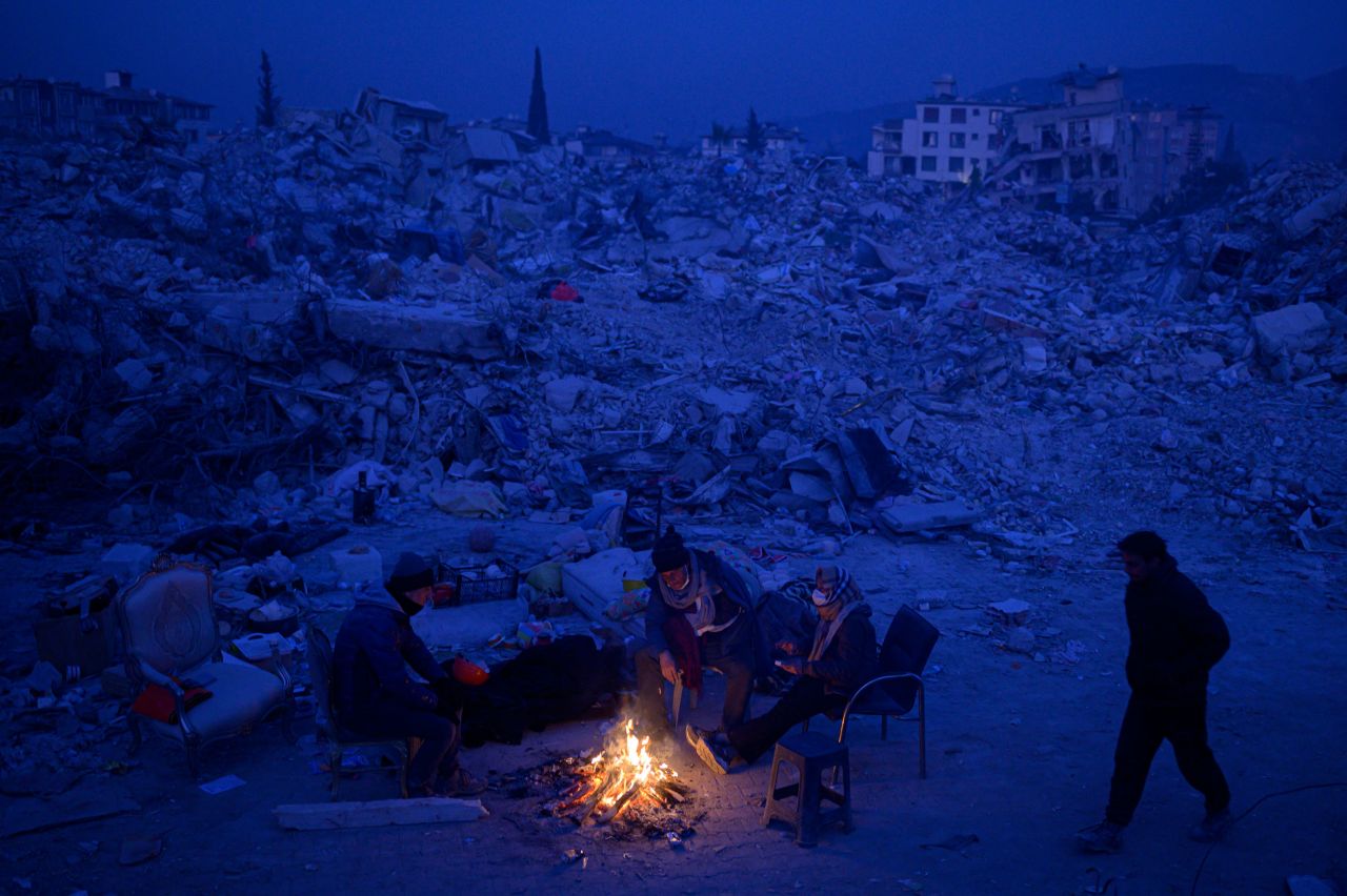 People sit by a bonfire, waiting for news of their relatives near the rubble of collapsed buildings in Hatay, Turkey, on Tuesday, February 14. <a href="http://www.cnn.com/2023/02/09/world/gallery/photos-this-week-february-2-february-9/index.html" target="_blank">See last week in 33 photos</a>.