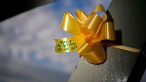     Yellow ribbons and heart-shaped paper notes decorated with messages of hope and goodwill are tied to the footbridge in the village of St Michael on Wyre.
