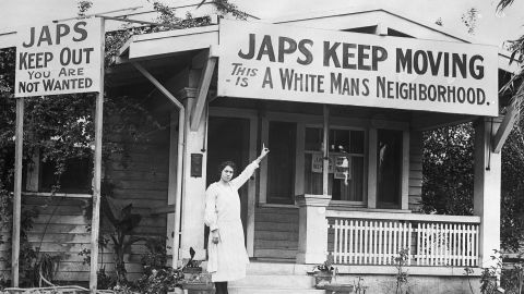 In 1923, the Hollywood Association started a campaign to expel the Japanese from their community. Hollywood resident, Mrs. B. G. Miller, points to an anti-Japanese sign on her house.