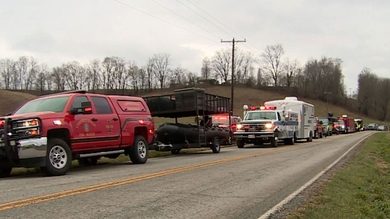 Rescue workers at the scene of a vehicle submerged in Kentucky flood waters