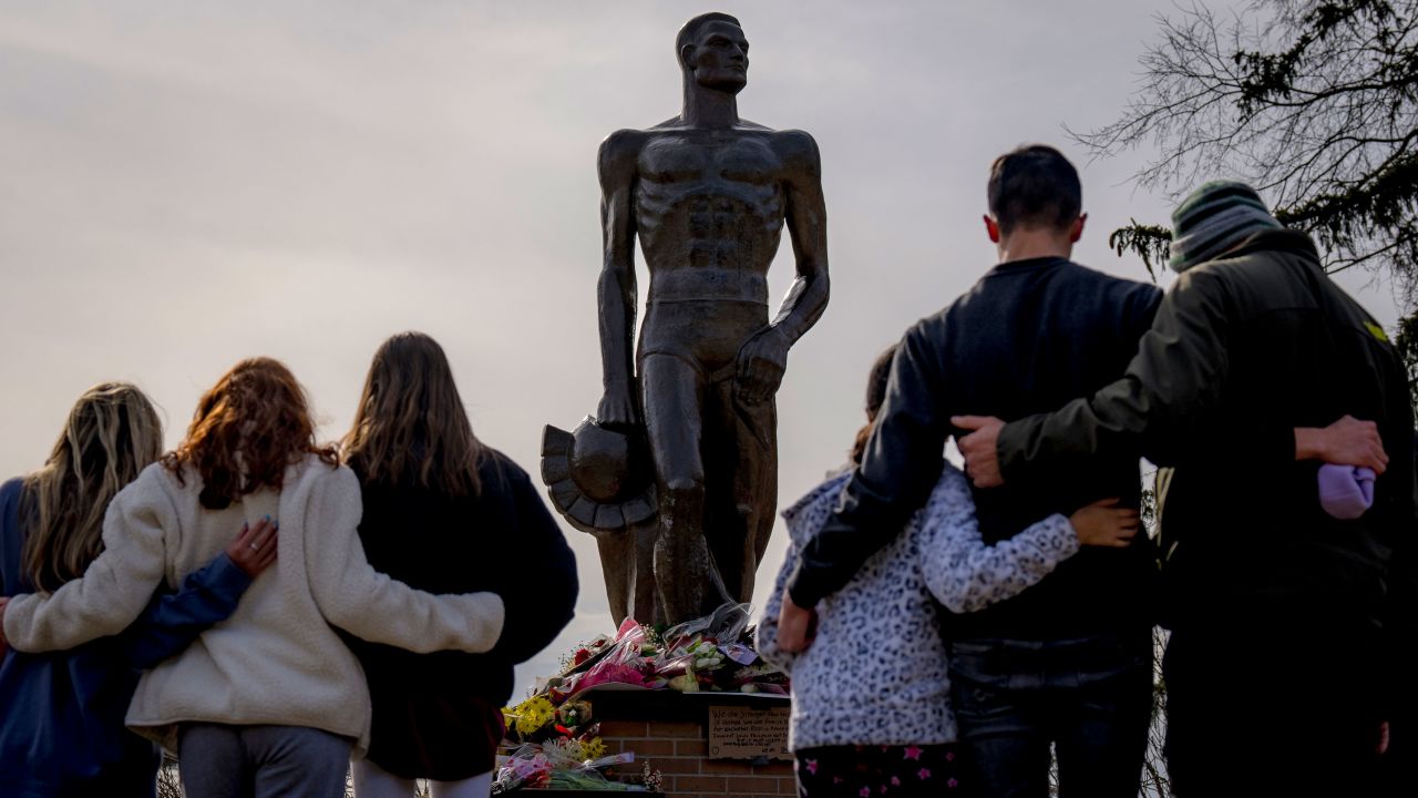 People embrace at the memorial that formed around The Spartan Statue at Michigan State University in East Lansing, Michigan, on Februrary 14, 2023. 