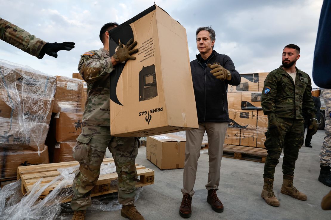Blinken helps US military personnel load aid onto a vehicle at Incirlik Air Base in Turkey on February 19, 2023. 
