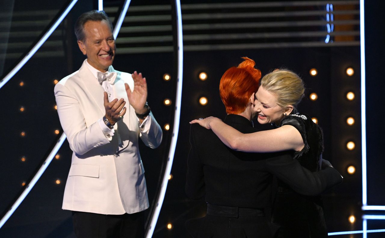 Richard E. Grant looks on as Cate Blanchett hugs Fellowship Award winner Sandy Powell.