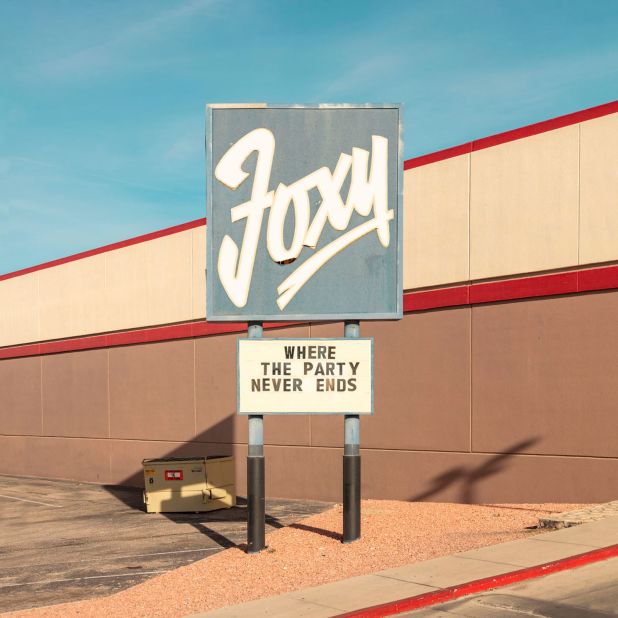 Many of the facades feature signs and slogans, such as "Where the Party Never Ends" at Foxy in El Paso, Texas.
